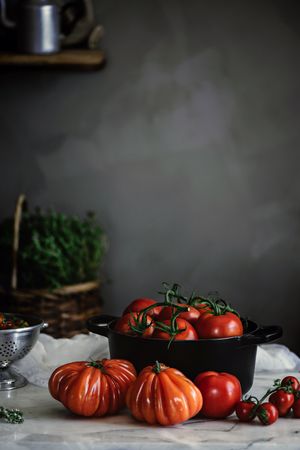 Ripe fresh tomatoes in pot on table