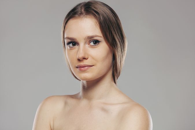 Blond woman without shirt posing in studio
