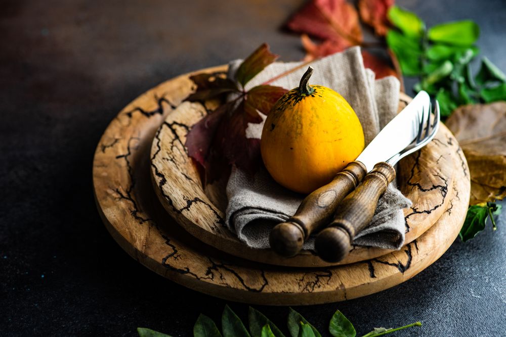 Rustic Thanksgiving table setting with squash on brown tableware