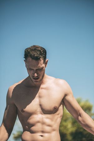 Handsome muscular man in sunny day