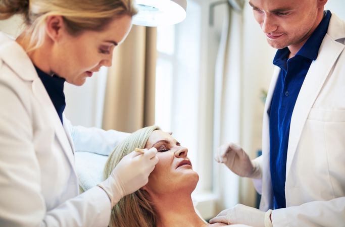 Two dermatologists working on botox treatment with patient