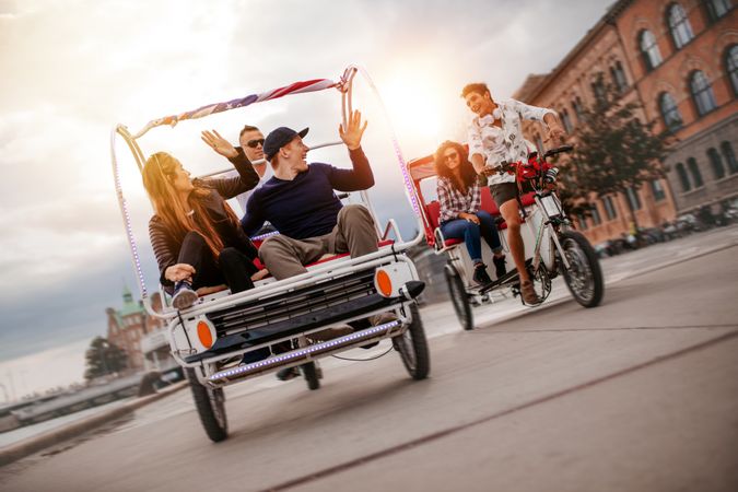 Group of friends riding passenger tricycles in the city