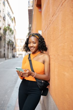 Portrait of a young Black woman using smartphone in the street