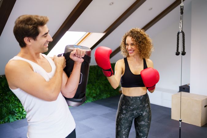 Happy couple practicing boxing in home gym