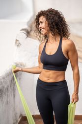 Woman working out biceps with resistant bands