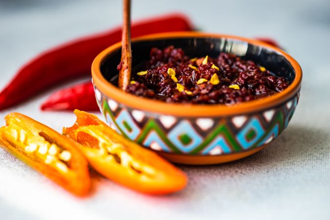 Traditional Georgian sauce Adjika in patterned bowl with spicy peppers