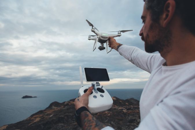 Man with drone and remote on overcast day