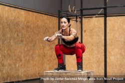 Fit woman doing box jump in gym bYqgag