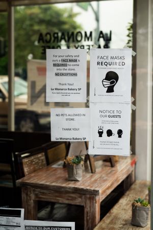 Signs in coffee shop requiring masks and social distancing
