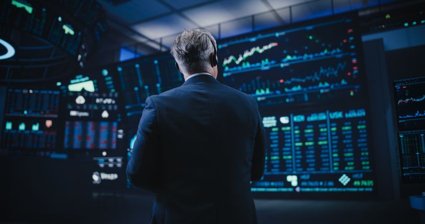 Back View of a Stock Exchange Trader Following a Live Auction, Communicating Buy and Sell Orders to Operator on the Other Side of the Call.