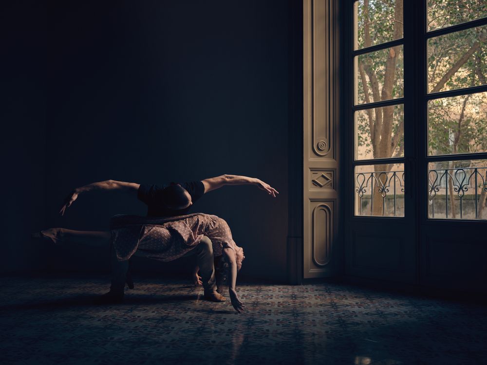 Couple dancing ballet in obscure room