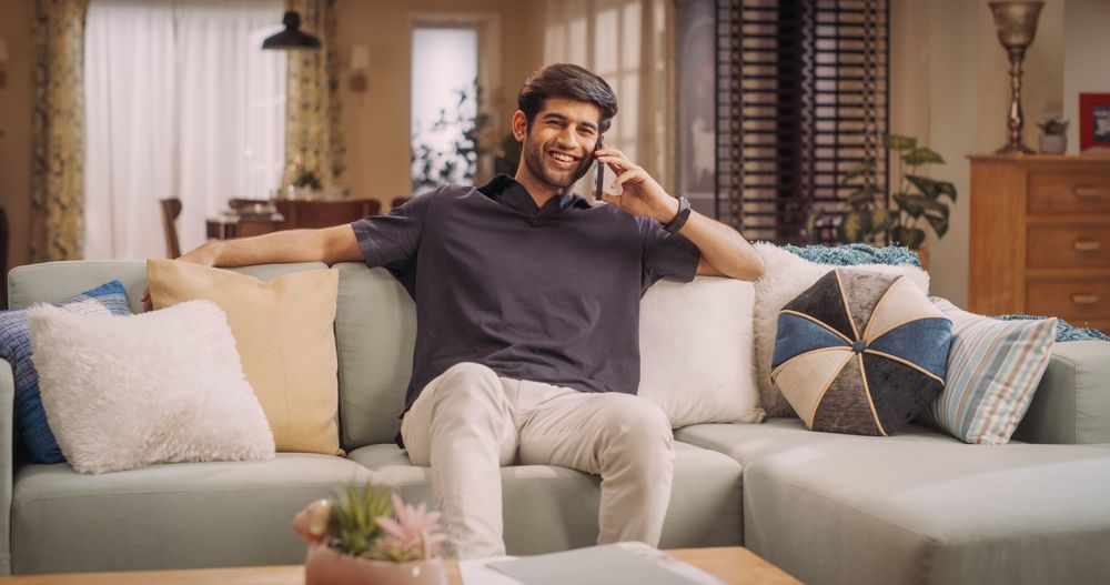 Charismatic Indian Man Engaged in Phone Call, Doing Remote Work and Social Life.