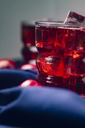 Red beverage near fresh fruits on cloth