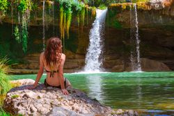 Young female relaxing near waterfall