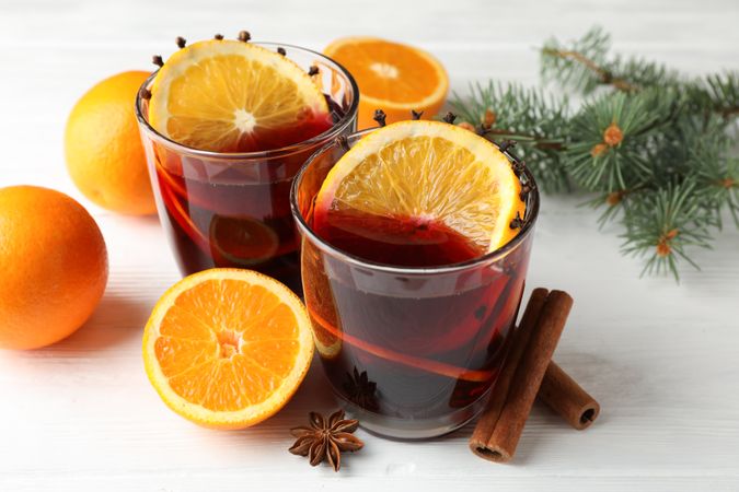 Glasses of tasty mulled wine with orange on wooden background, close up