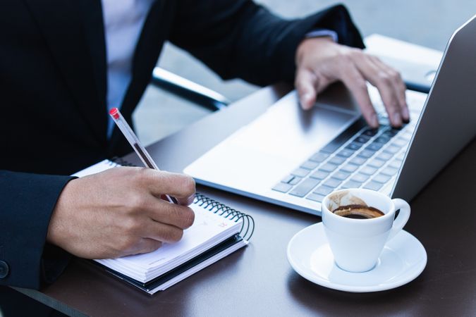 Serious male entrepreneur in suit working in cafe