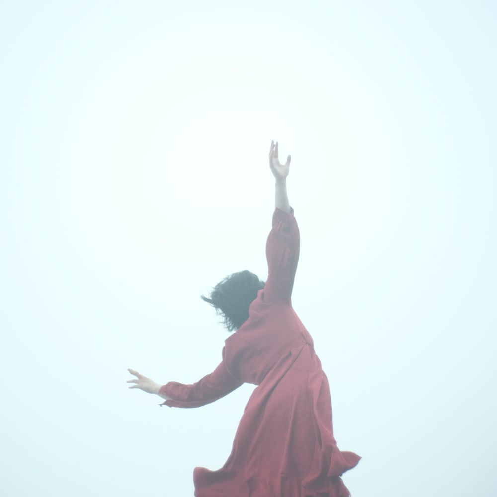 Woman in red dress raising her right hand