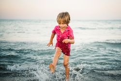 Playful boy splashing water on coast