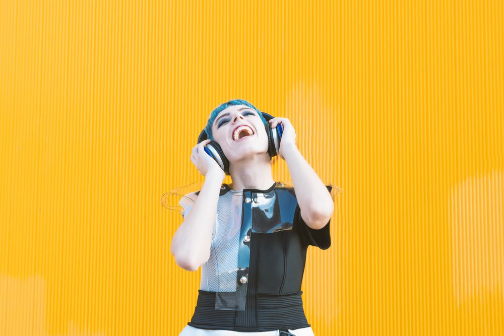 Cool informal woman in headphones on street