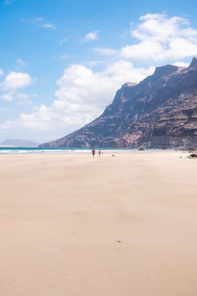 Back of two people walking on beach in Lazarote