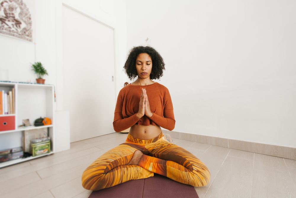 Sportive woman sitting in yoga pose with closed eyes