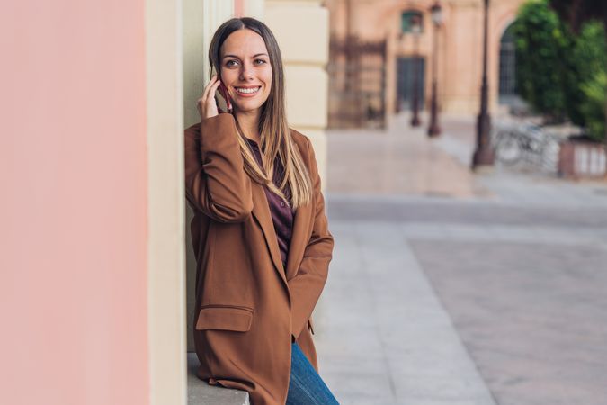 Pleased female in stylish outfit on street smiling away
