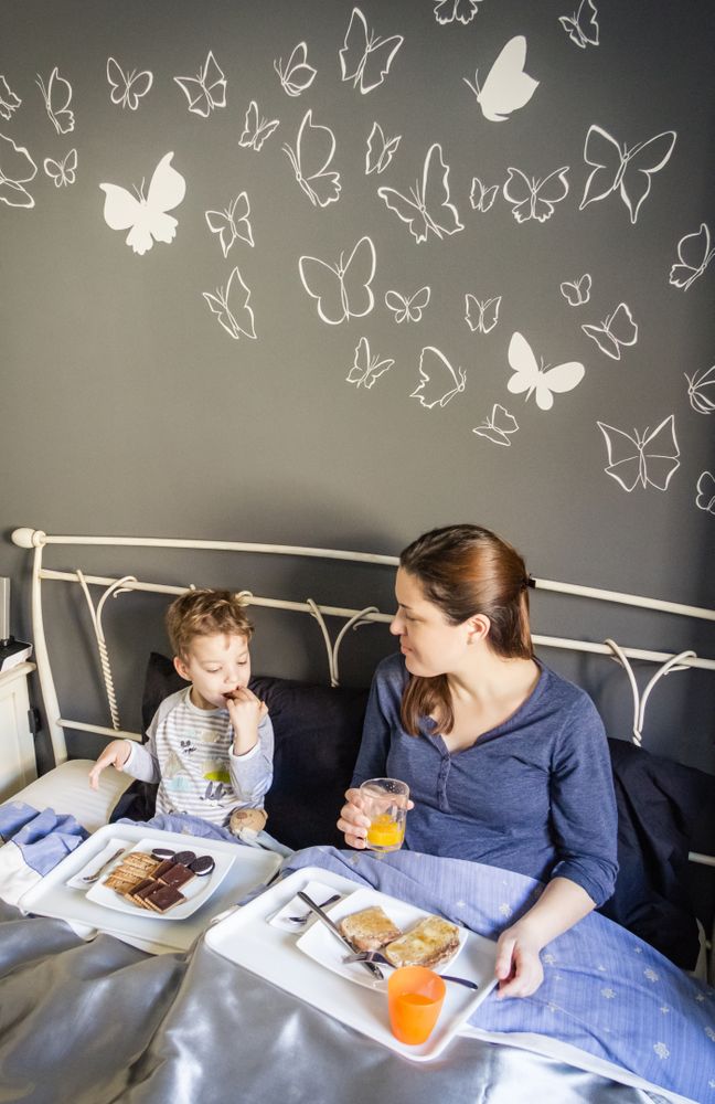 Mother and son having breakfast in bed