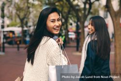 Young woman in knit sweater laughing with shopping bag 5nPZmb