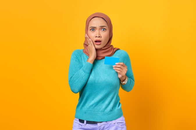 Muslim woman surprised and holding credit card