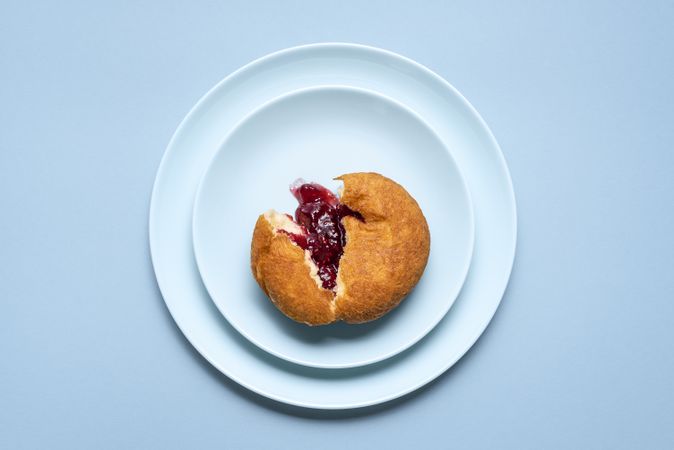 One jelly donut cut on a plate