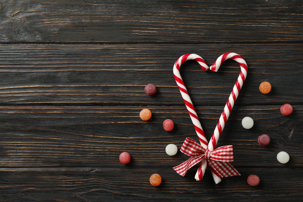 Composition with sweet candies on wooden background, space for text