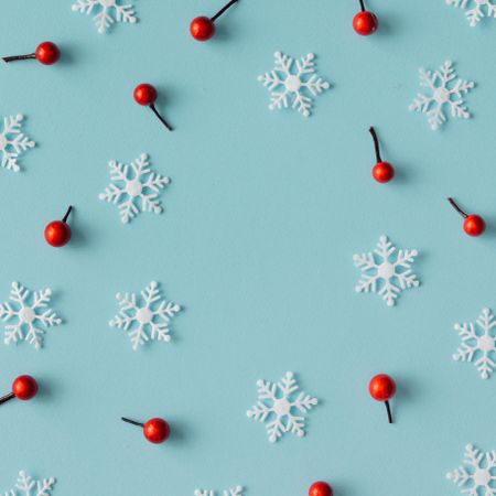 Christmas pattern made of snowflakes and red berries on blue background