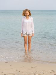 Young woman in water on shore