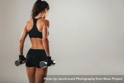Back of athletic woman holding weights 0V6O7D