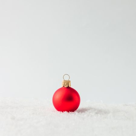 Red Christmas bauble on snow
