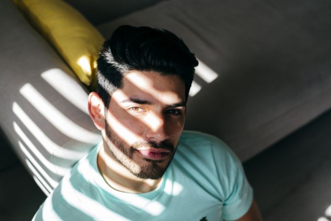 Young sad man sitting on couch at home