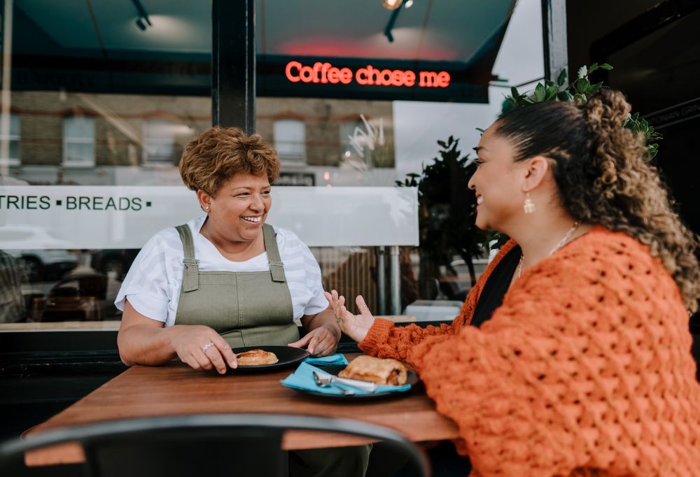 Mother and daughter enjoying lunch at outdoor cafe table
