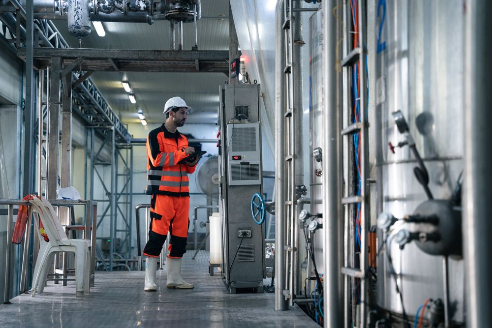Engineer worker checking machine of conveyor belt system at the canned food factory.