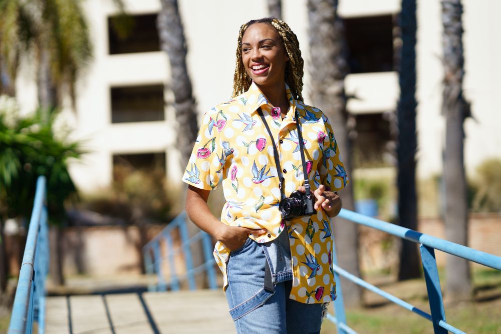 Female photographer in yellow printed pattern on pedestrian bridge