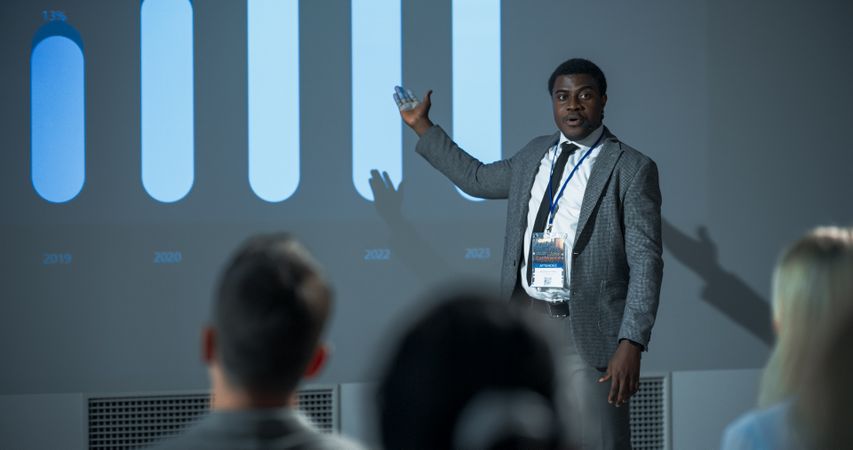 Successful Black Businessman Giving Presentation At International Business Conference.