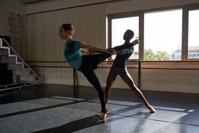 Couple of Black male and white woman in a class doing a training in ballet academy