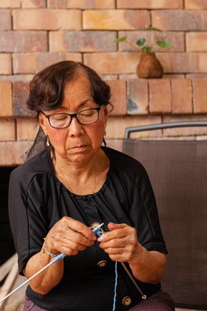 Tranquil threads. Mature Latina woman's knitting retreat.