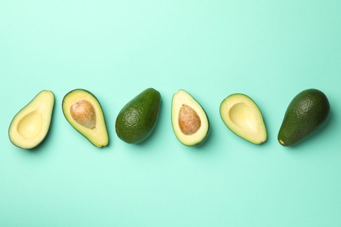 Ripe fresh avocado on mint background, top view