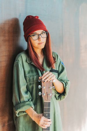 Woman in glasses leaning on wall