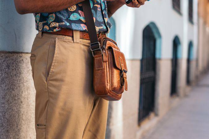 Stylish Black man using smartphone outdoors in the city