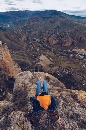 Faceless woman resting on mountain top