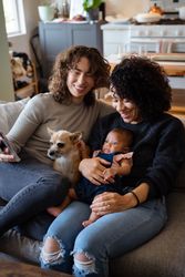 Two women with dog and baby on sofa