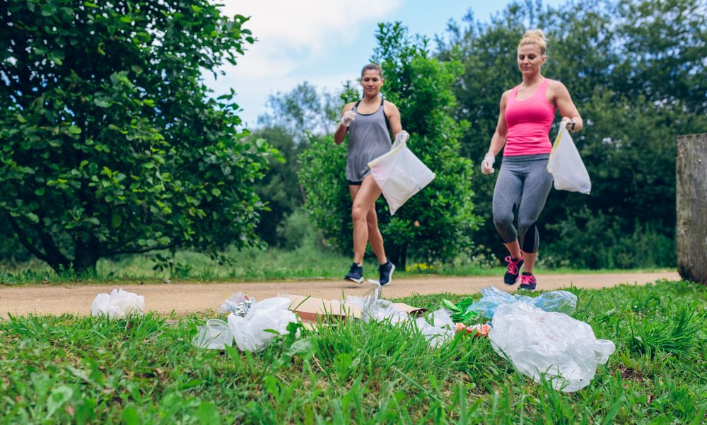 Waste pile and two woman doing plogging