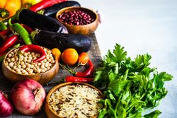 Fresh vegetables and grains on wooden board with copy space