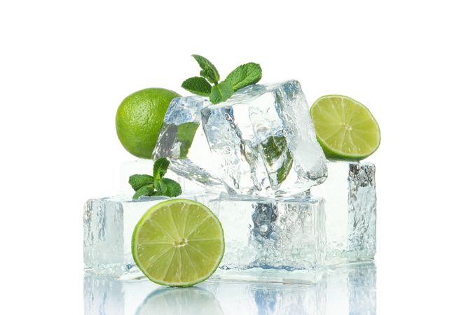 Stack of ice cubes with halves of lime, and mint leaves